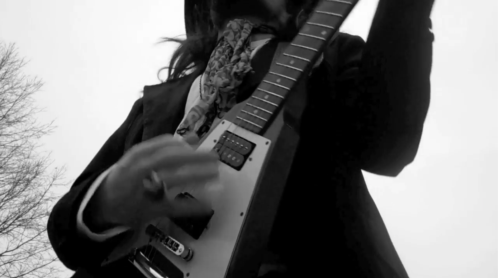 Black-and-white image of Leroy Powell playing a white Flying V in a dark jacket