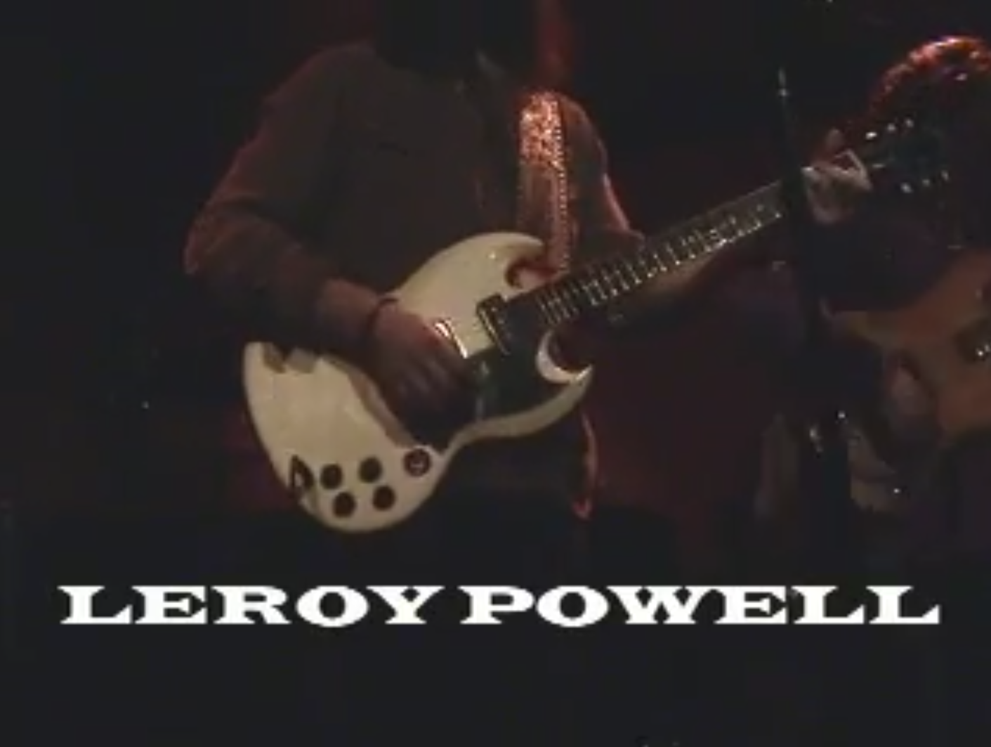 Leroy Powell playing a white Gibson-style guitar with Leroy Powell lettering below
