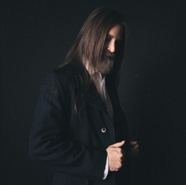 Dark studio portrait of Leroy Powell in a black coat
